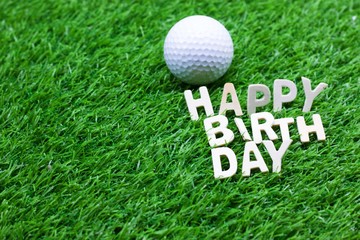 Happy birthday to golfer word on green grass with golf ball