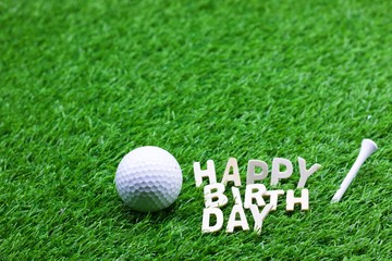 Happy birthday to golfer word on green grass with golf ball
