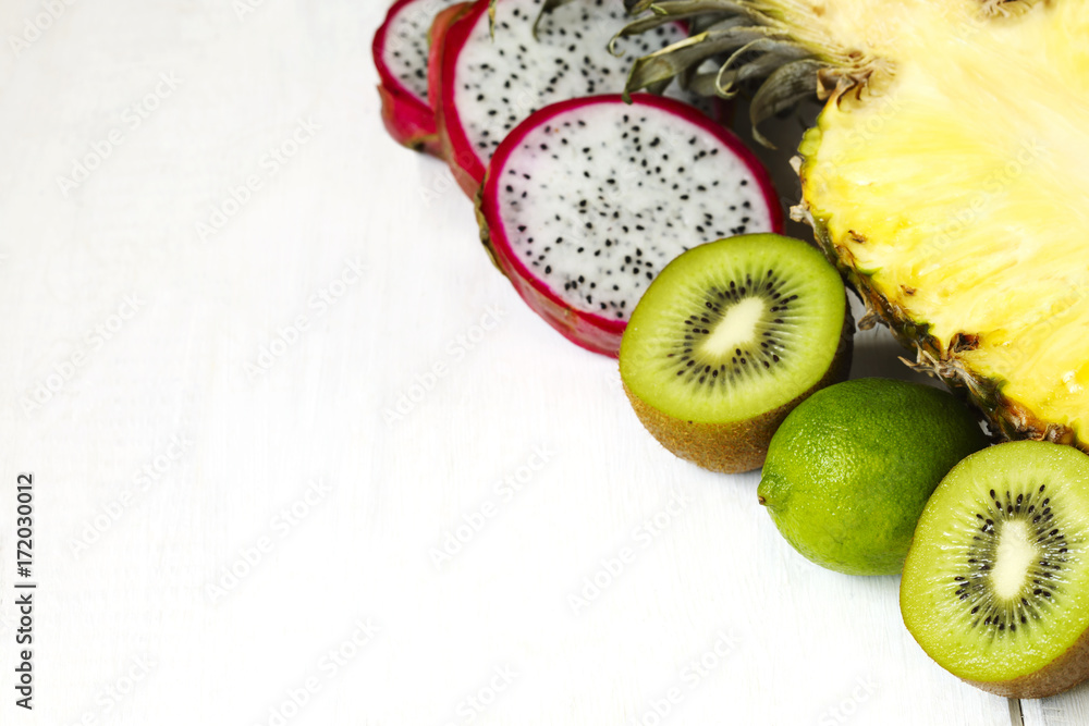 Wall mural Assortment of exotic fruits on white background with copy space