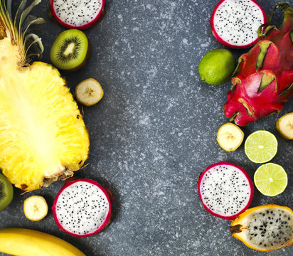 Assortment of exotic fruits on grey stone background with copy space