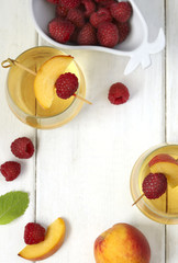 Peach wine and fruits on white wooden table, top view