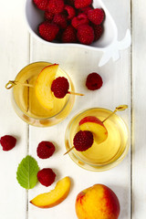Peach wine and fruits on white wooden table, top view