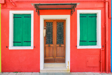 Picturesque windows with shutters of red house on the famous island Burano, Venice, Italy