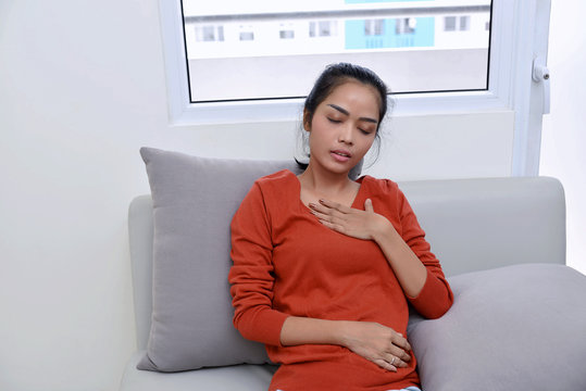 Young asian woman feeling pain in her chest