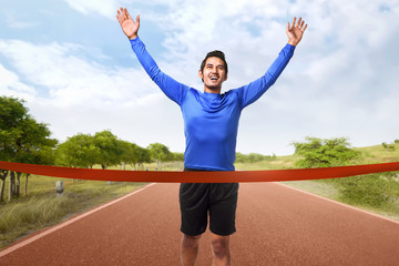 Portrait of asian man running crossing the finish line