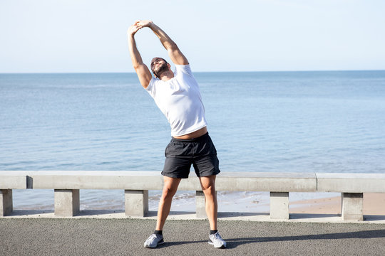 Muscular Man Doing Side Bend Exercise Outdoors