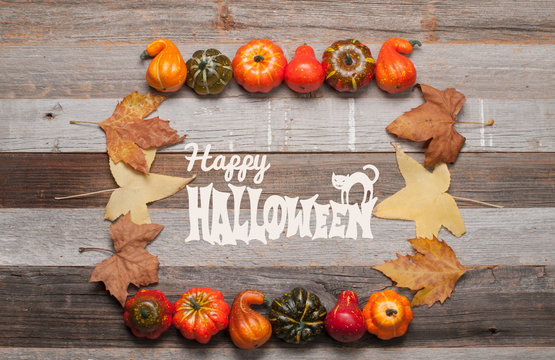 Pumpkins and fall leaves on wooden background. Halloween. Autumn concept