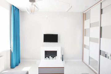 Interior of light modern living room with fireplace