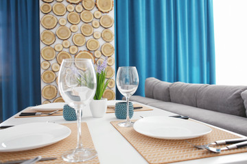 Interior of light modern dining room with served table