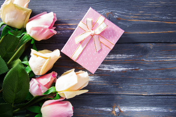 Bouquet of pink roses and gift box.