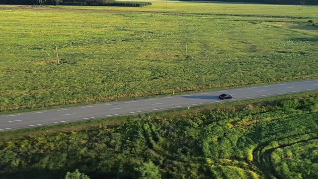 aerial view of sport car driving in fields