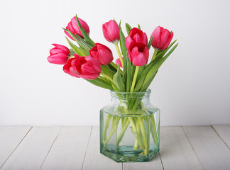 bunch of red tulip flowers  in a glass vintage jar
