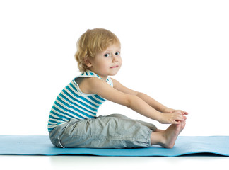 Naklejka premium Child boy practicing yoga, stretching in exercise. Kid isolated over white background