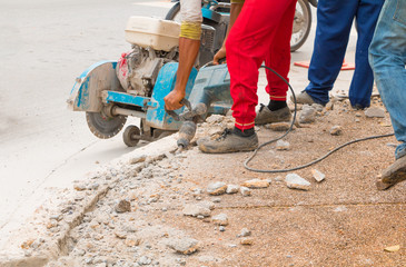 construction drilling repair worker on road surface with heavy duty machine drill motion