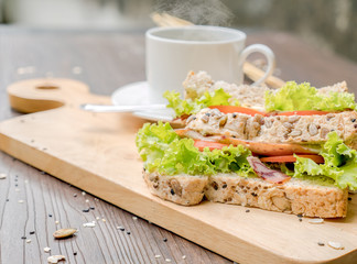 Wholewheat healthly sandwich served with hot coffee on wooden plate