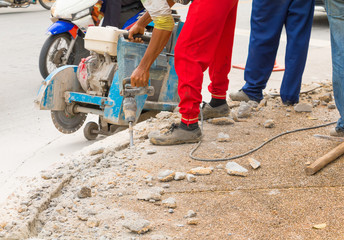 construction drilling repair worker on road surface with heavy duty machine drill motion