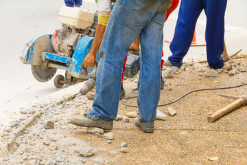 construction drilling repair worker on road surface with heavy duty machine drill motion
