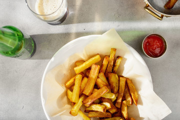 Plate of fries with ketchup and glass of dark beer