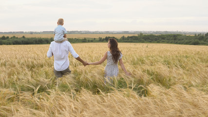 Happy childhood, family walking on the wheat field © lenblr