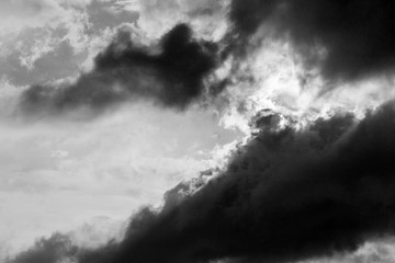 A close view of some moody and big clouds with half of the sun covered by them