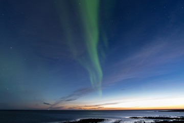 Aurora Borealis, Northern light over the sea at twilight dawn Iceland.