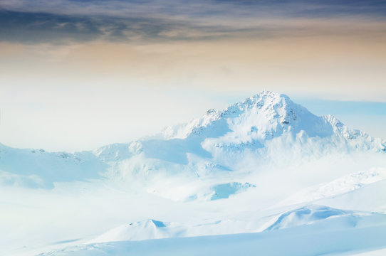 Snow-covered mountains at sunset.