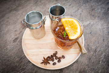 Cold brew coffee with lemon on wooden table.