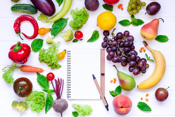 Healthy food, diet eating, detox background - different fruits and vegetable, empty open notebook, and measuring tape on white wooden table. Top view. Selective focus.