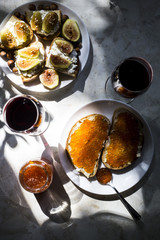 two glasses of red wine with sandwiches with red caviar and bruschettes with cheese and figs. in the kitchen