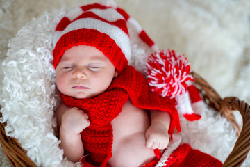 Little sleeping newborn baby boy, wearing Santa hat
