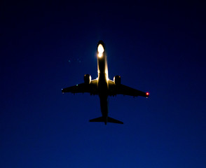 Silhouette of a landing aircraft at sunset