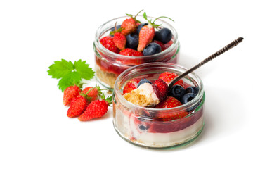 Mini  wild forest berries cheesecake in a glass pots isolated on white background