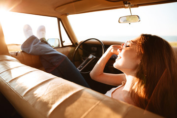 Image from car of pleased brunette woman lying on seat