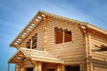 Structure of a new wooden house under construction on blue sky background