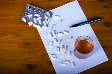 Abschiedsbrief mit Tabletten, Füller und Getränk