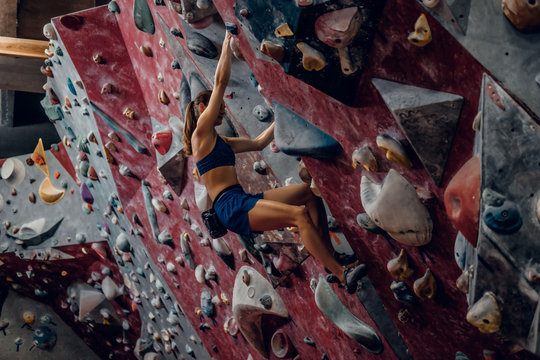 Female climber. Extreme indoor climbing.