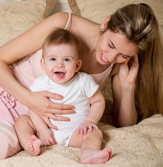Mother and baby playing and smiling. Happy family.Home interior. Laughing baby