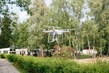 Videography wedding ceremony from the air a small spy quad copter scout drone flying through the trees in forest.