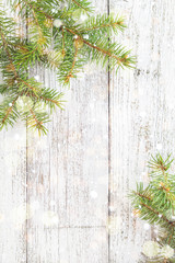 Christmas wooden background with fir tree, snow and bokeh. Top view copy space