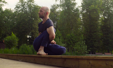 A man doing yoga exercises in the park