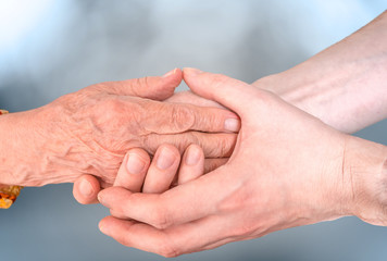 Man holds hands of eldery woman. Senior help concept.