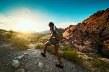 woman hiking at Red Rock Canyon during sunset with backpack
