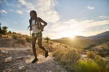 woman hiking at Red Rock Canyon during sunset with backpack