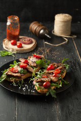 Delicious sandwich with meat with arugula and tomatoes