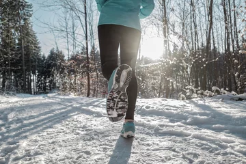 Foto auf Acrylglas Joggen Woman Running at snowly winter under sunlight.