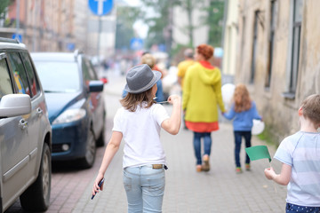 A small group of children is walking along the city street