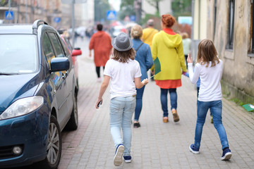 A small group of children is walking along the city street