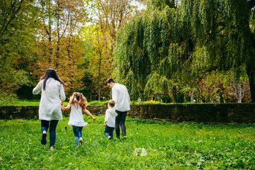happy family running in city park
