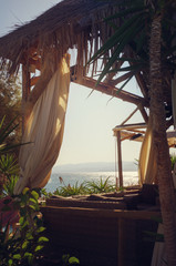 Wooden canopy decorated with white curtains on the seashore © redche