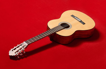 acoustic guitar on red velvet fabric, closeup object